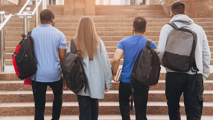 Group of college students walking across a sunny campus